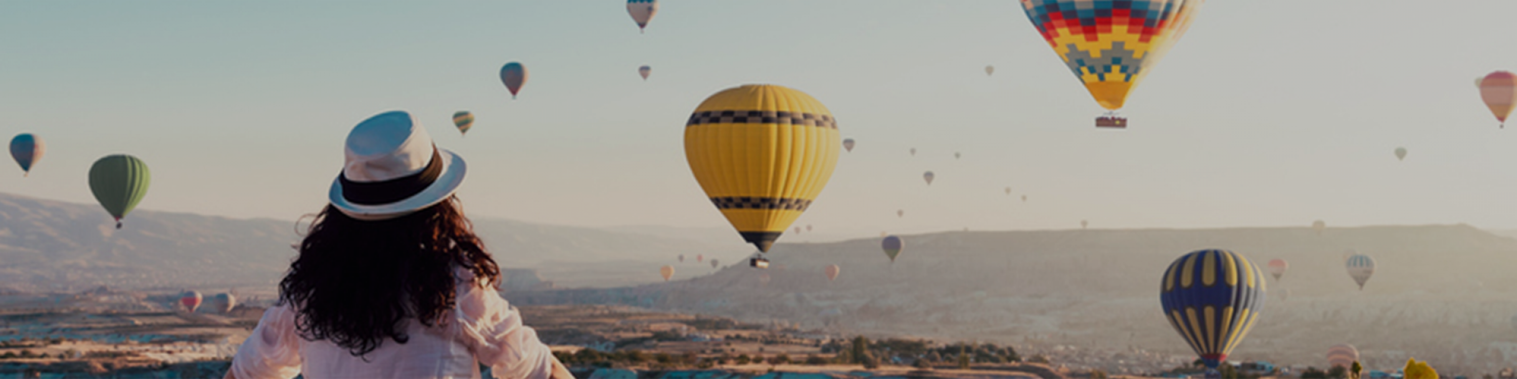 Woman looking out at hot air balloons