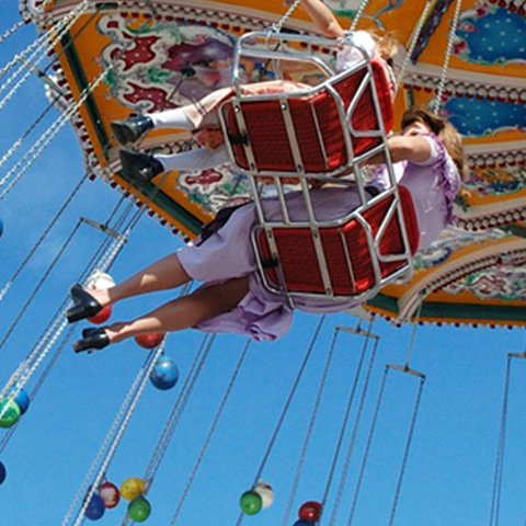Families at the fair on a swing ride 