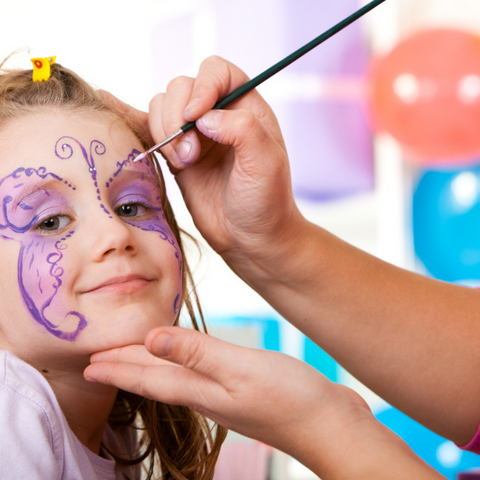 Little girl having face painted