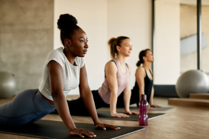 three females practicing yoga indoors