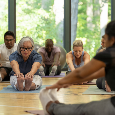 Group of middle aged adults practicing yoga indoors
