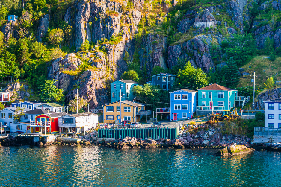 Morning light illuminates colorful homes on the rocky shore of The Narrows, an inlet entering St. John's Harbor in Newfoundland, Canada