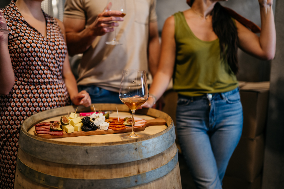 charcuterie board on wine barrel with glass of wine