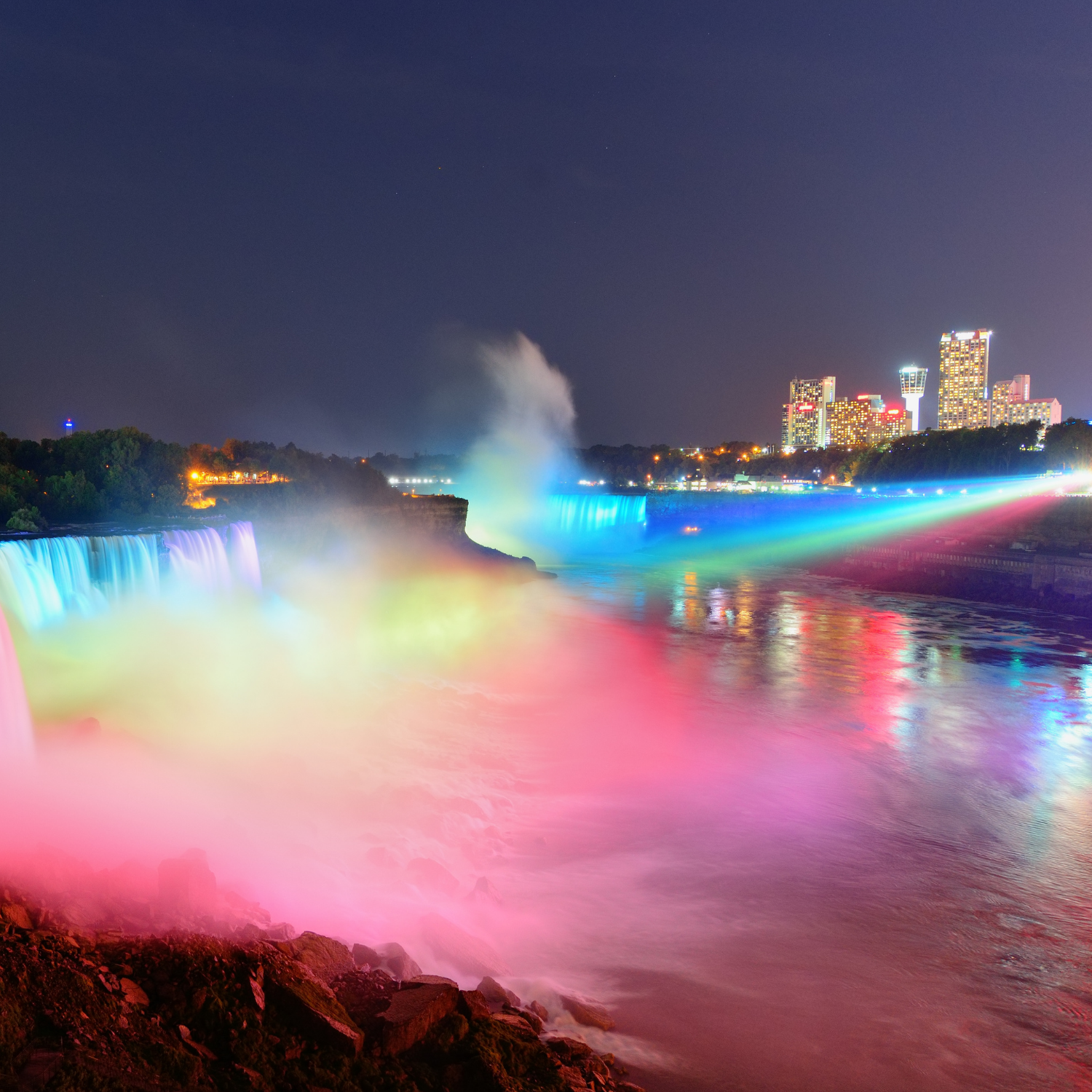 Niagara Falls lit at night by colorful lights