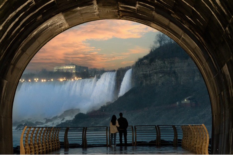 couple looking at the falls at sunset from the niagara parks power station tunnel