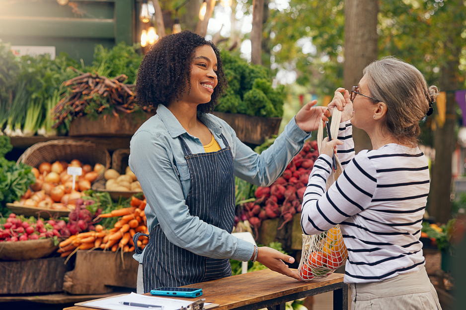 woman purchasing produce at an outdoor market