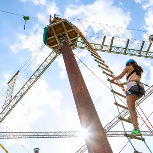 A child climbing across a high ropes course