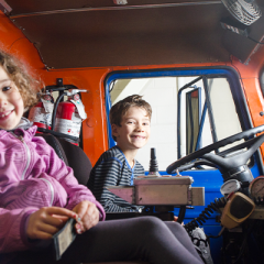 Young girl and boy sitting in a fire truck
