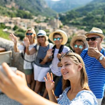 group of travellers taking selfies with a view of mountains behind