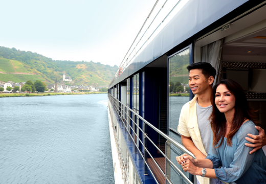 Couple looking out to the water from their balcony