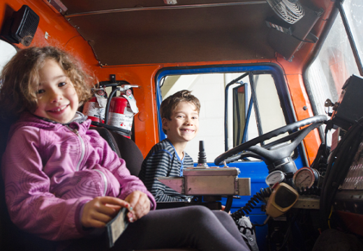 Young girl and boy sitting in a fire truck