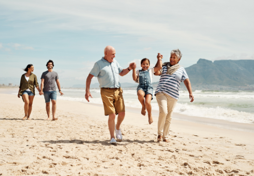 little girl at the beach with her parents and grandparents