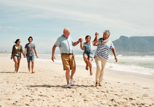  little girl at the beach with her parents and grandparents