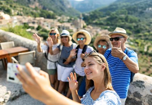 group of travellers taking selfies with a view of mountains behind