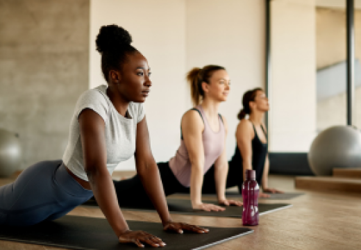 three females practicing yoga indoors