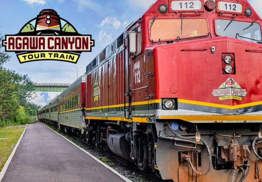 Red train on track in Agawa, with Agawa Train Tour logo