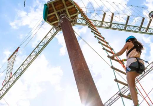 A child climbing across a high ropes course
