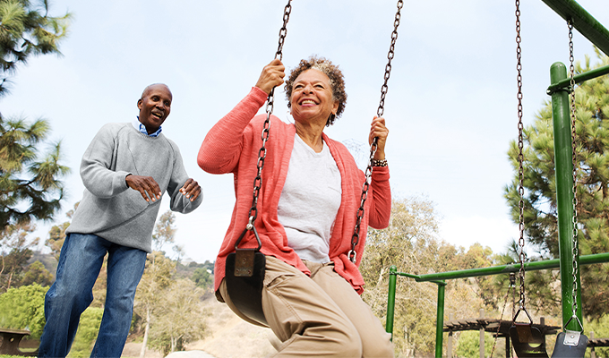 Older couple playing on swings