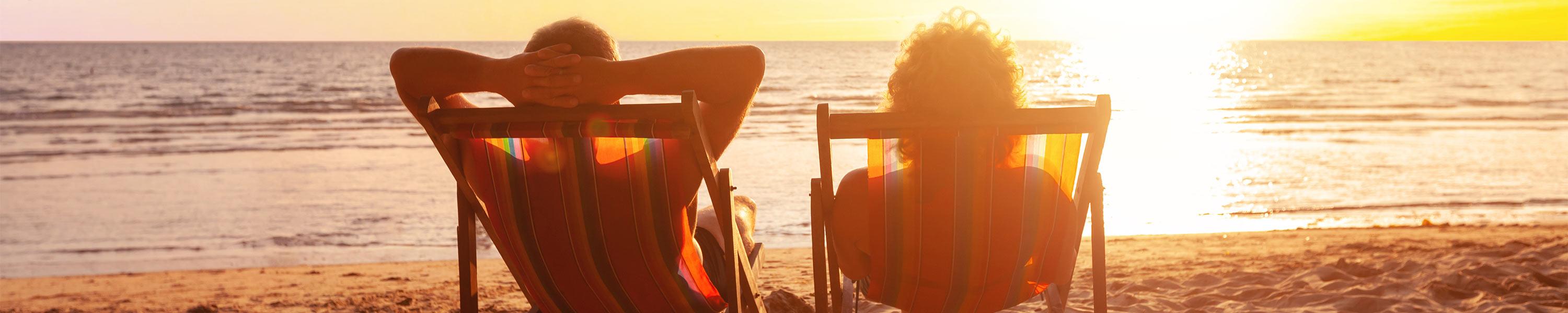 Couple relaxing on the beach at sunset