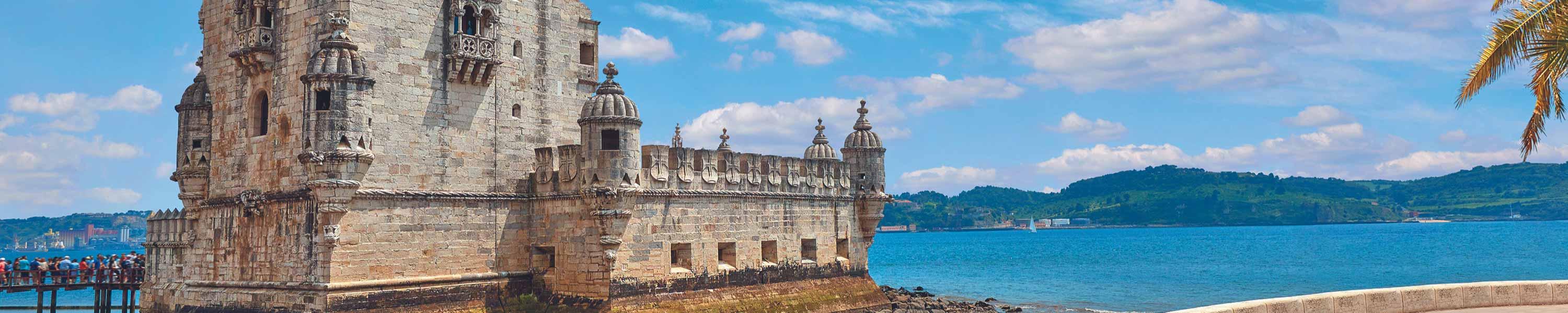 Lisbon, Portugal. Tower Belem at coast. Embankment alley with palm tree