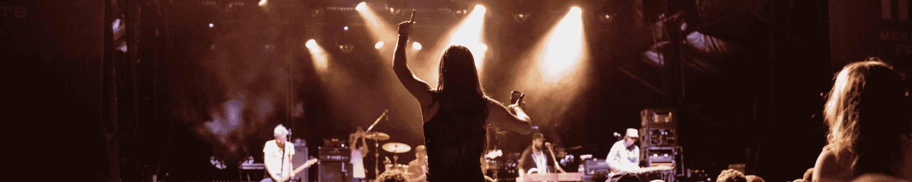 Silhouette of Woman Cheering for a Band