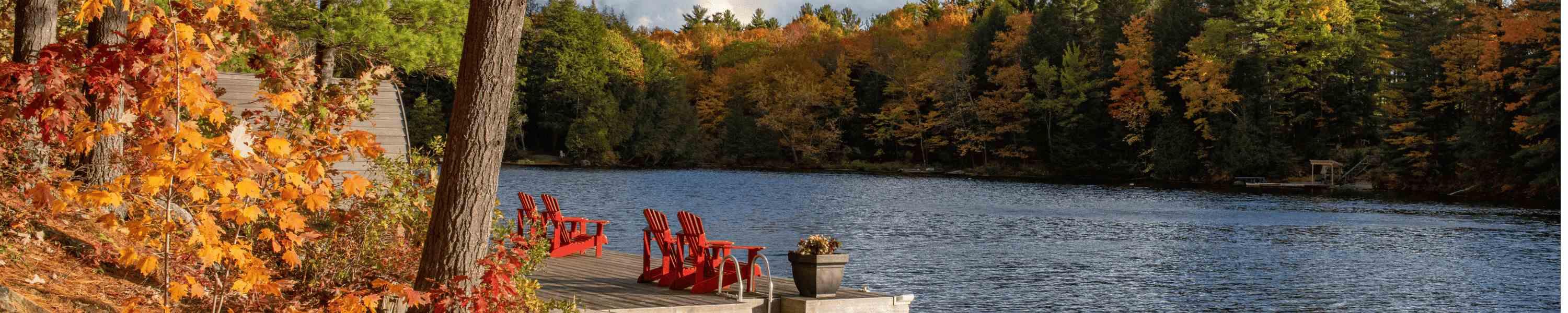 Muskoka chairs along a river