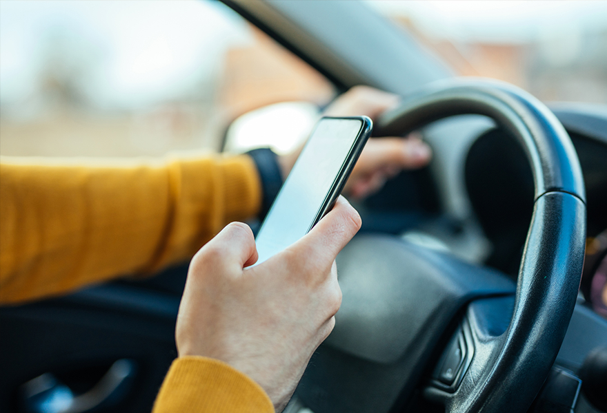 Motorist holding cell phone while driving.