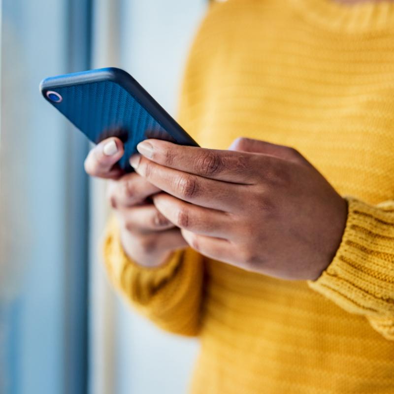 Shot of an unrecognizable woman using a mobile phone indoors