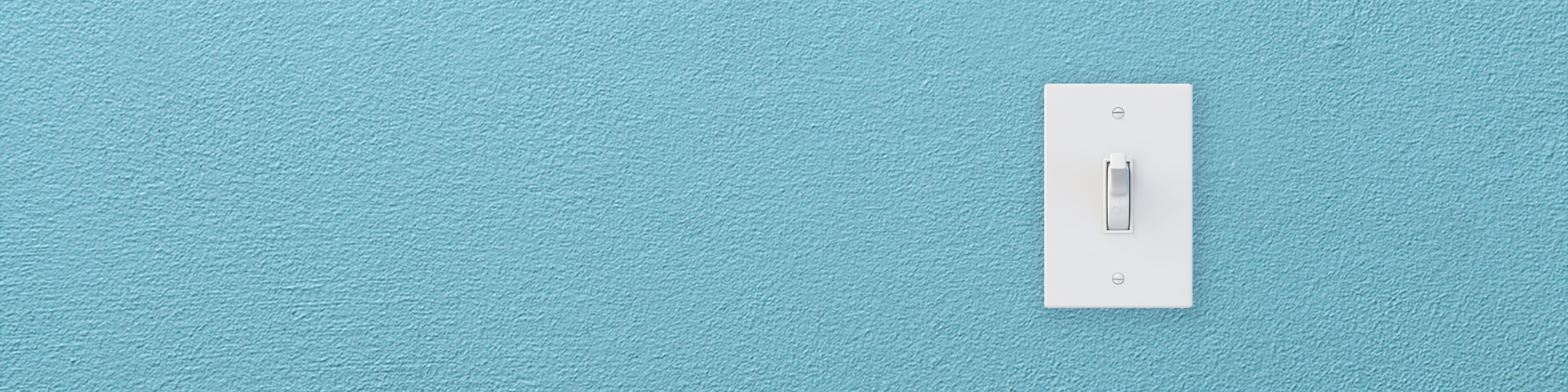 Light swich on blue wall switched on.